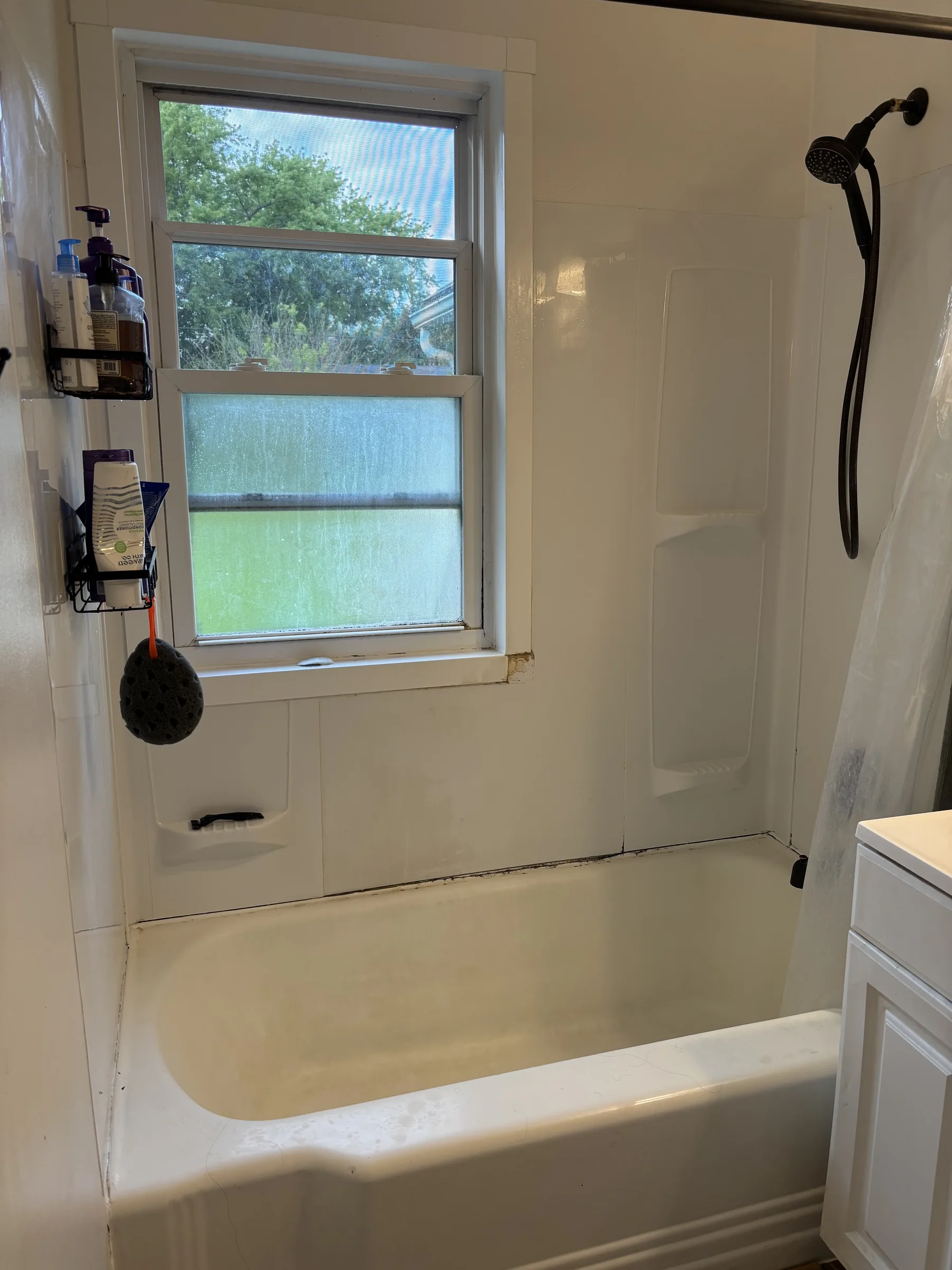 Original dated bathtub and shower surround before renovation